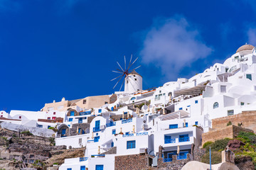 Naklejka premium Santorini landscape with view of whitewashed buildings and windmills in Oia, Greece