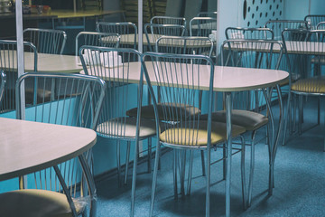 Empty tables in a closed cafe with mirror wall