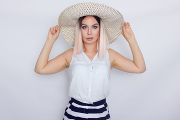 Young blonde woman with big white summer hat