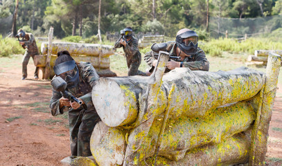 Fototapeta premium Paintball players aiming and shooting with guns