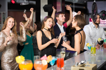 Positive colleagues dancing with cocktails