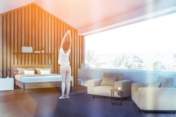 Woman in attic wooden bedroom