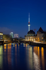 Cityscape of Berlin. Old and modern buildings and their reflections on the Spree River in Germany, at dusk. Fernsehturm TV Tower is in the background.