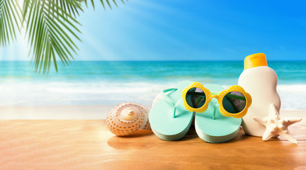 Fototapeta na wymiar Sunblock with flip flops on the tropical beach and sunshine