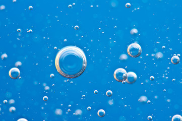 Bubbles of oxygen surging upward in blue water.