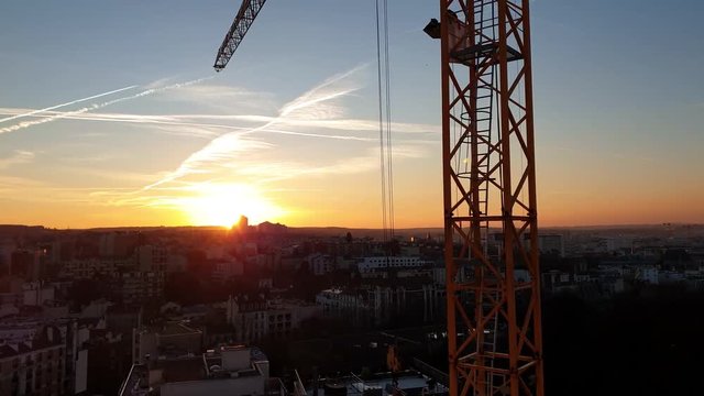 Une grue en fonctionnement sur le chantier d'un immeuble en construction au cr&eacute;puscule