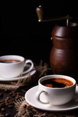 two cups of coffee on a dark background