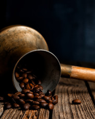 coffee beans spill out of the Turks on an old wooden table