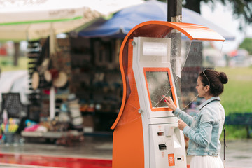 Tourist woman buys tickets for transport in Georgia. modern street machine for purchase of tickets...