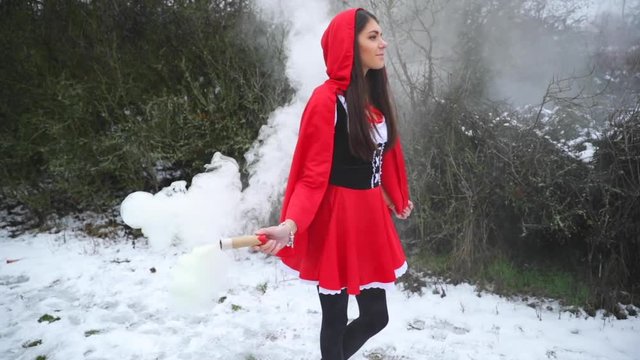 Thick Smoke Smoke Grenade passes through a model in a red suit in winter on snow captured in slow motion.