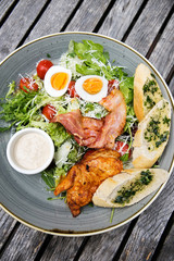 Chicken ceasar salad. Chicken, pancetta, eggs, tomatoes with garlic bread with caesar sauce. 