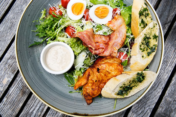 Chicken ceasar salad. Chicken, pancetta, eggs, tomatoes with garlic bread with caesar sauce. 