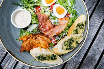 Chicken ceasar salad. Chicken, pancetta, eggs, tomatoes with garlic bread with caesar sauce. 