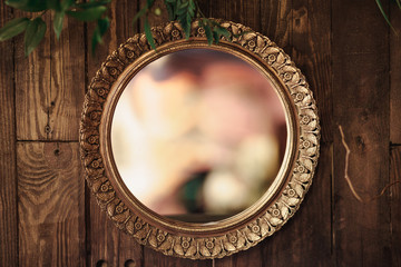 antique mirror with gold frame on wooden background - obrazy, fototapety, plakaty