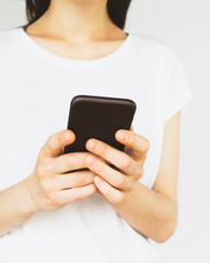 a woman in a white t-shirt uses a smartphone