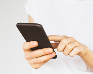 a woman in a white t-shirt uses a smartphone
