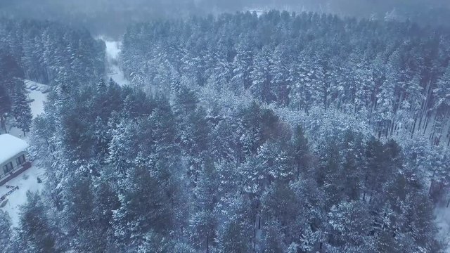 Top view of the hotel in the forest in winter. Clip. Snow-covered path along the hotel in the evening