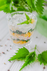 Exotic salad with nettles and eggs in a glass lined in layers.