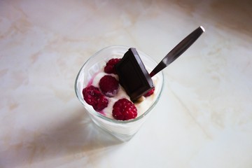 Cheesecake in a glass with raspberries and chocolate.