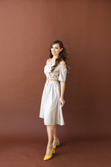 European young brunette woman is standing in the studio and smiling.