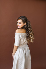 European young brunette woman is standing in the studio and smiling.