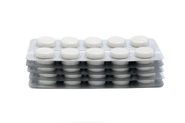 white pills in packaging sheets on white background