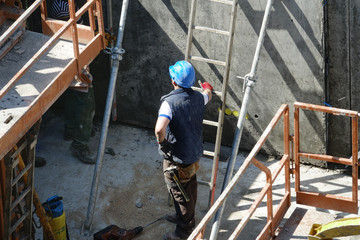 Obraz na płótnie Canvas Des ouvriers posant des étais sur le chantier d'un immeuble en construction