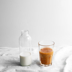 Bottle with milk and glass cup with coffee on the table. cold brew iced coffee