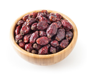 Dried wild rose berries in wooden bowl isolated on white background with clipping path