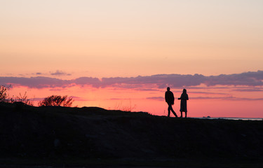 couple walking on the beach at sunset