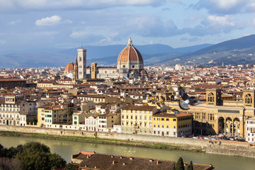 Amazing view on Florence city and its main cathedral dome (Santa Maria del Fiore dome). Awesome cityscape of Florence roofs, Italy. Florence from above, near observation deck. River arno and a dove.