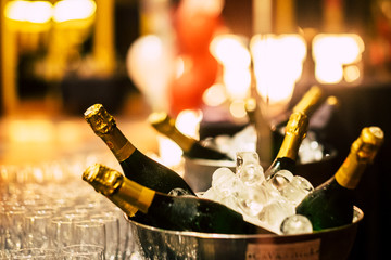 Night event party celebration concept with fluts glasses and wine champagne bottles ready to be drinked from people - bokeh defoused light background © simona