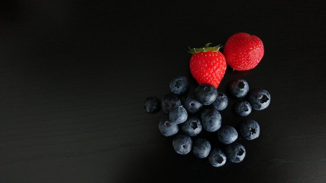 Blueberries and Strawberries on Black Background