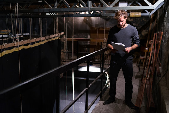 Actor at theatre studying script backstage