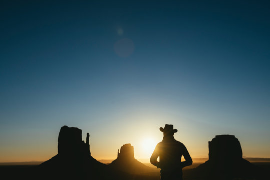 USA, Utah, Monument Valley, Silhouette Of Man With Cowboy Hat Watching Sunrise