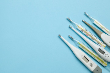 Medical thermometers glass and electronic on blue background. Copy space for text.