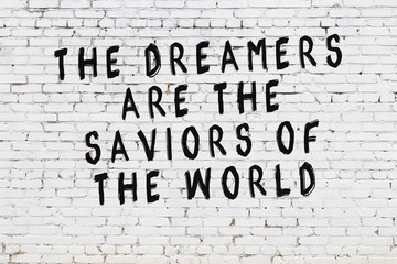 White brick wall with painted black motivational quote inscription