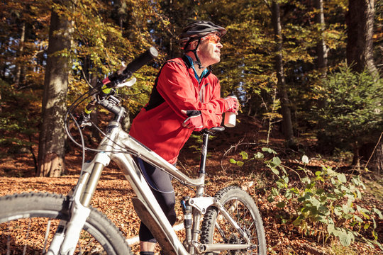Man with mountain bike having a break in forest