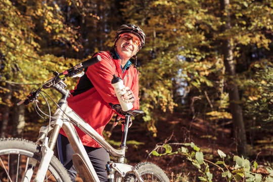 Man with mountain bike having a break in forest
