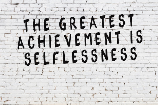 White brick wall with painted black motivational quote inscription