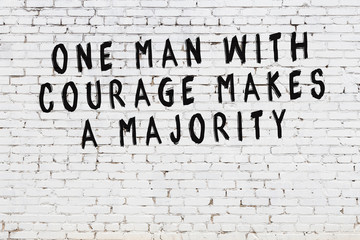 White brick wall with painted black motivational quote inscription