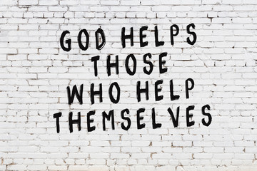 White brick wall with painted black motivational quote inscription