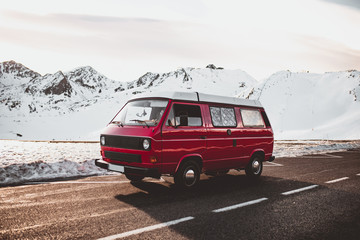 Red caravan riding near snowy mountains