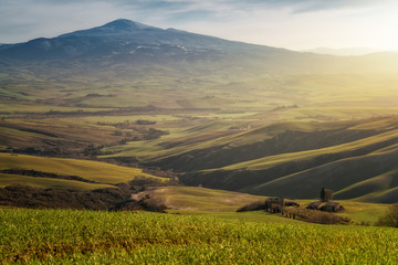 Majestic landscape of green valley with fields and mountain range in Tuscany, Italy