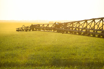 Jets of liquid fertilizer from the tractor sprayer.