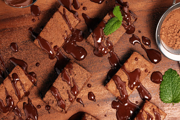 Brownie dessert. Cake chocolate brownies on wooden background with mint.