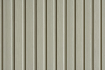 Element of the facade. Part of the facade decoration close-up. Facing material of buildings. Metal sheet roof. Vertical sheet. Grey.