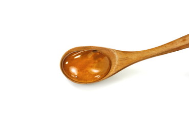 Honey in a wooden spoon isolated on white background.