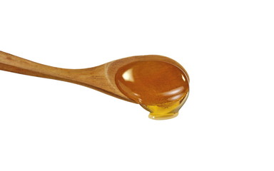 Honey in a wooden spoon isolated on white background.