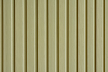 Obraz premium Element of the facade. Part of the facade decoration close-up. Facing material of buildings. Metal sheet roof. Vertical sheet. Brown.